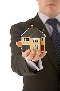 Businessman Holding Small House 