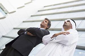 Two businessmen standing outdoors by building (high key/selective focus)