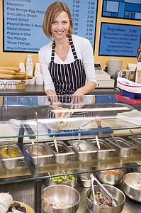 Woman standing at counter in restaurant smiling