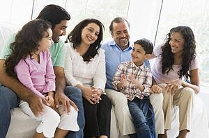 Family sitting in living room smiling (high key)