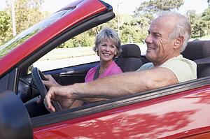 Couple in convertible car smiling