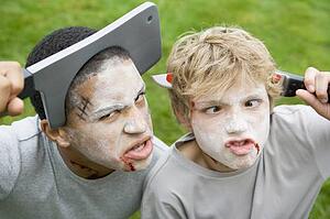 Two young boys with scary Halloween make up and plastic knives through their heads