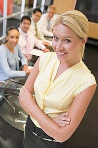 Businesswoman with four businesspeople at boardroom table in background
