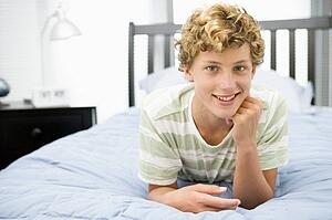 Teenage Boy Lying On Bed