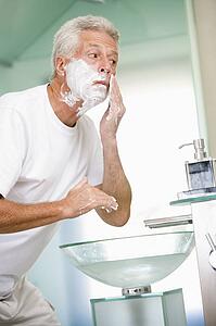 Man in bathroom shaving