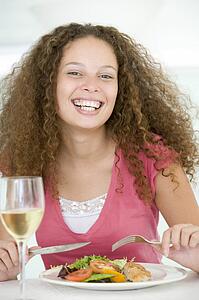 Woman Eating meal, mealtime With A Glass Of Wine 