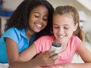 Young Girls Playing With A Cellphone