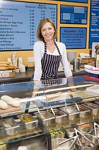 Woman standing at counter in restaurant smiling