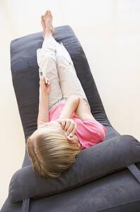 Woman sitting in chair listening to MP3 player