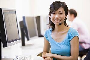 Woman wearing headset in computer room smiling