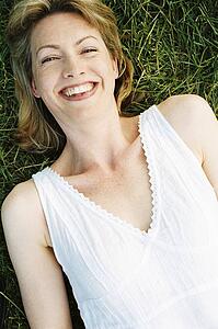 Woman lying outdoors smiling
