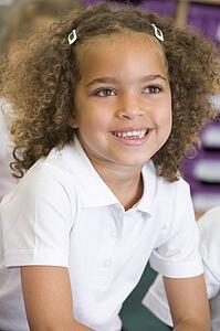 Student in class sitting on floor smiling (selective focus)