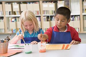 Two students in art class painting