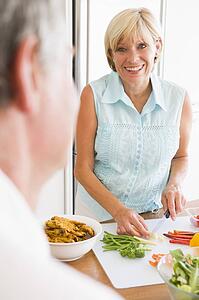 Woman Talking To Husband As She Prepares A meal, mealtime