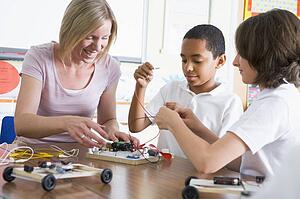Students in class with teacher making electronic cars