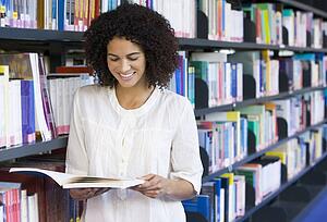 Woman in library reading book (depth of field)