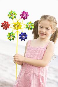 Young girl at beach with toy windmill smiling