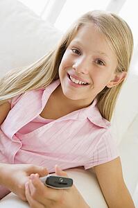 Young Girl Sitting On A Sofa Texting On A Cellphone