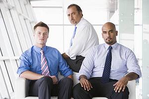 Three businessmen sitting indoors (high key/selective focus)