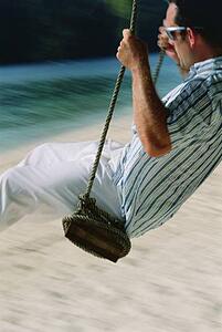 Man on a swing outdoors at the beach (blur)