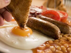 Dipping Toast into a Fried Egg on a Full English Breakfast