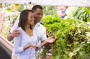 Young couple shopping for lettuce at a grocery store