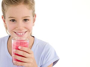 Young girl with glass of juice smiling
