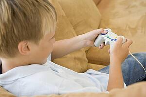Young boy in living room with video game controller