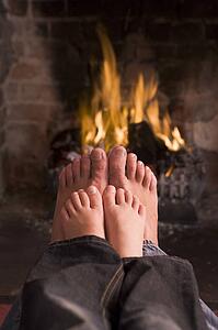 Father and son's feet warming at a fireplace