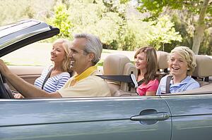 Family in convertible car smiling
