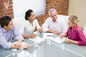 Four businesspeople in boardroom talking
