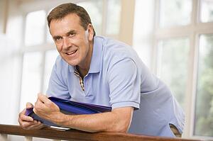 Teacher in corridor leaning on railing