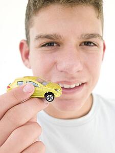 Young boy holding toy car and smiling