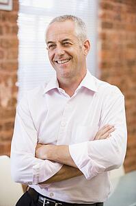 Businessman sitting in office space smiling