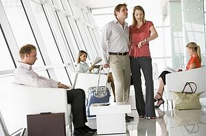 Couple waiting with other airline passengers in departure gate