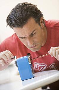 Man indoors using pencil sharpener