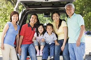 Extended family sitting in tailgate of car