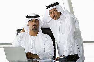 Two businessmen in office with laptop (high key/selective focus)