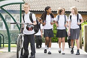 Students leaving school one with a bicycle
