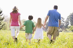 Family walking outdoors holding hands