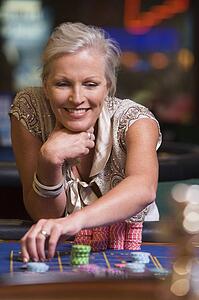 Woman in casino playing roulette and smiling (selective focus)