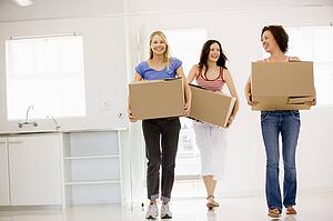 Three girl friends moving into new home smiling