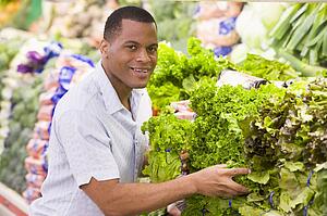 Man shopping for lettuce at a grocery store