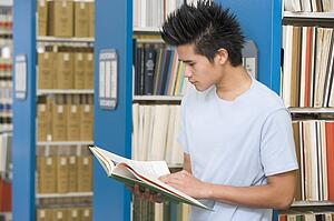 Man in library reading book (depth of field)