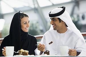 Couple at restaurant eating dessert and smiling (selective focus)