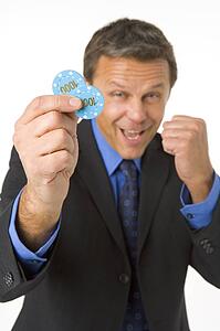 Businessman Holding Poker Chips To The Value Of $2000