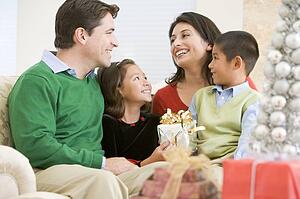 Family Smiling At Each Other, Holding Christmas Gift
