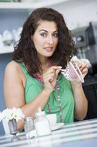 Young woman sitting at a table checking change purse