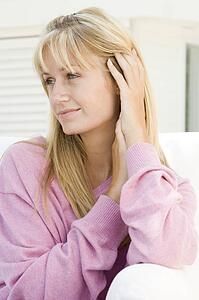 Blonde woman in a pink sweater posing outdoors