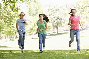 Teenagers Running Through Park